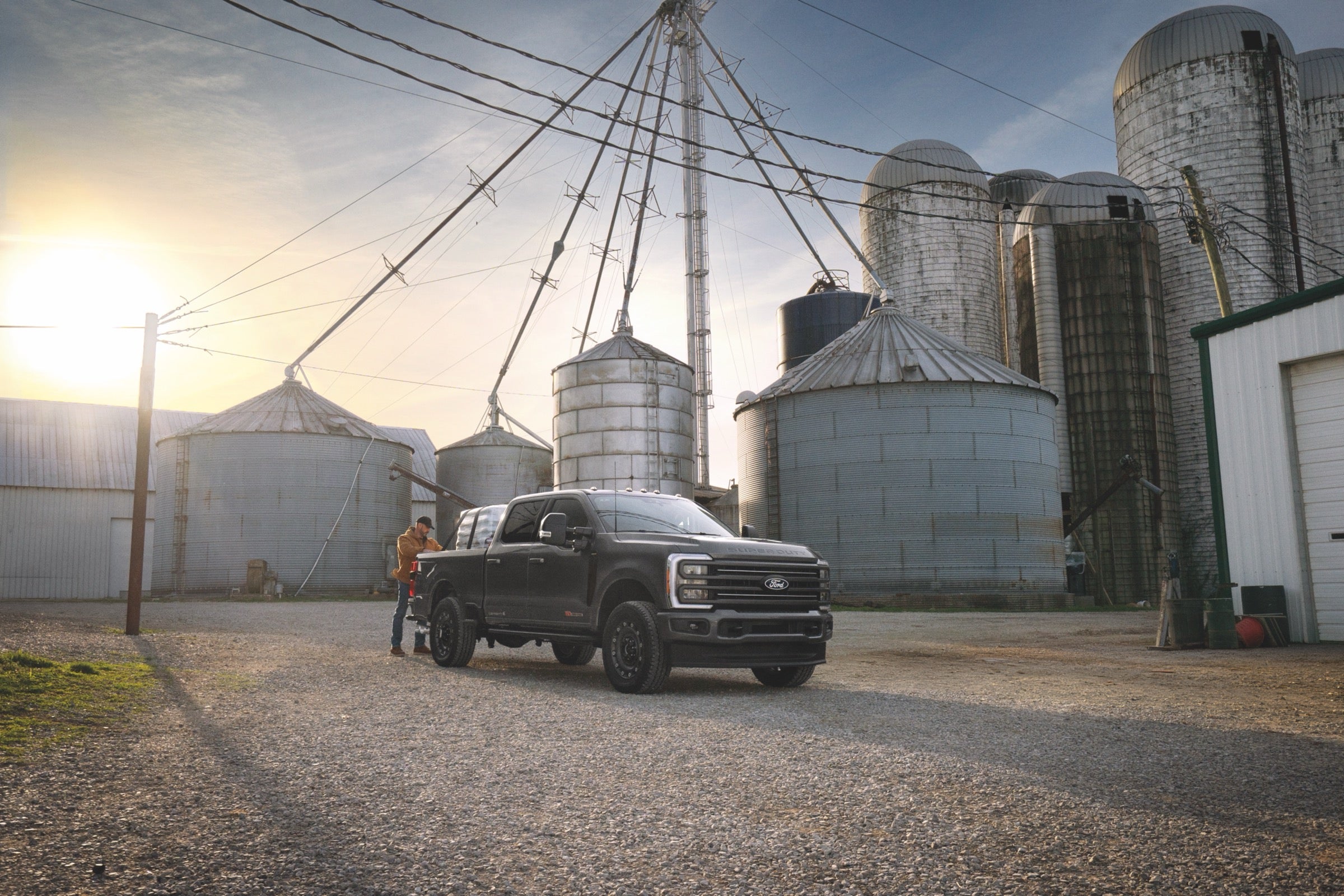 2027 Ford F-350 Super Duty at a working farm with grain silos in the background.