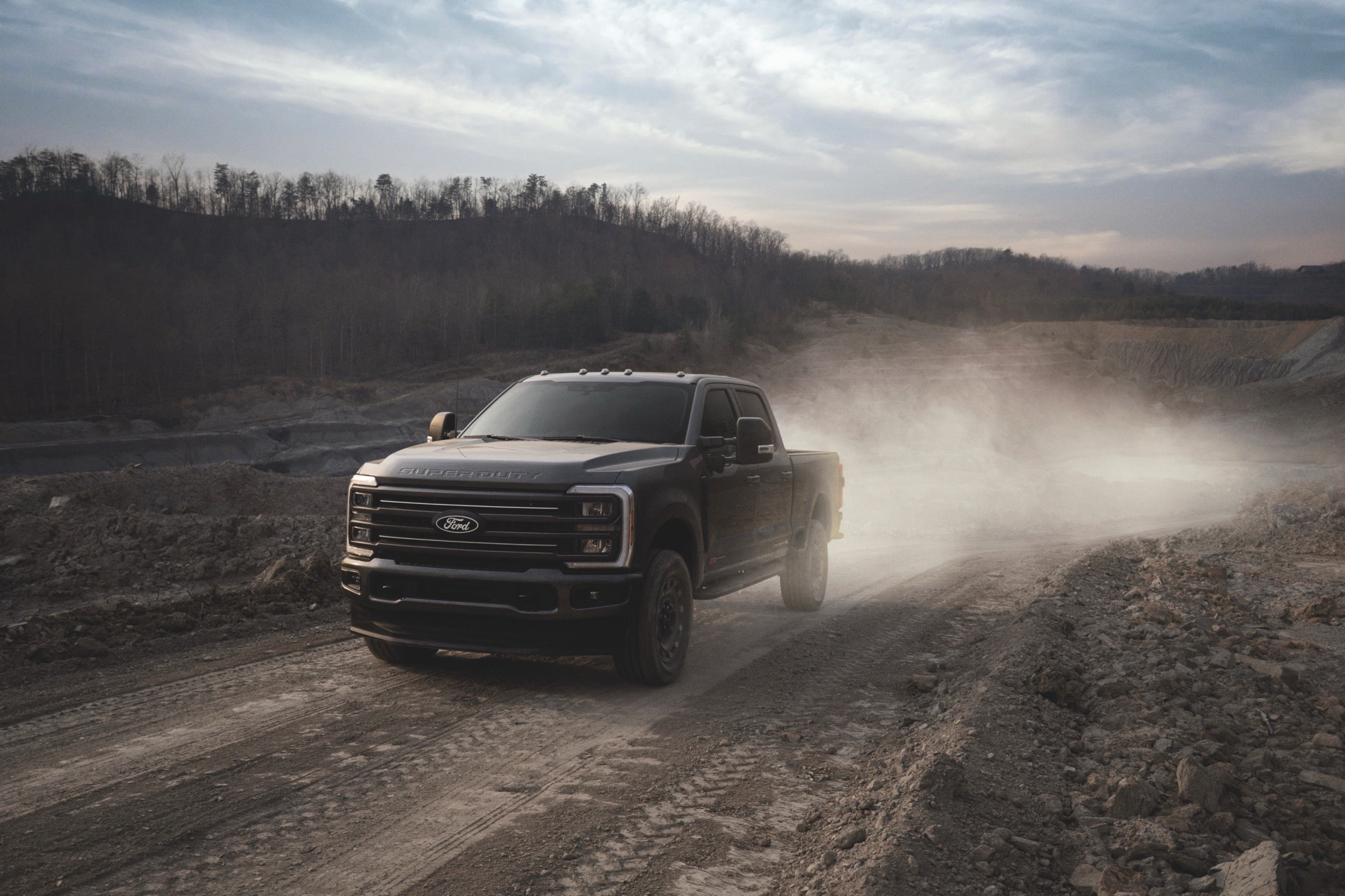 2027 Ford F-350 Super Duty driving through a dusty quarry worksite.