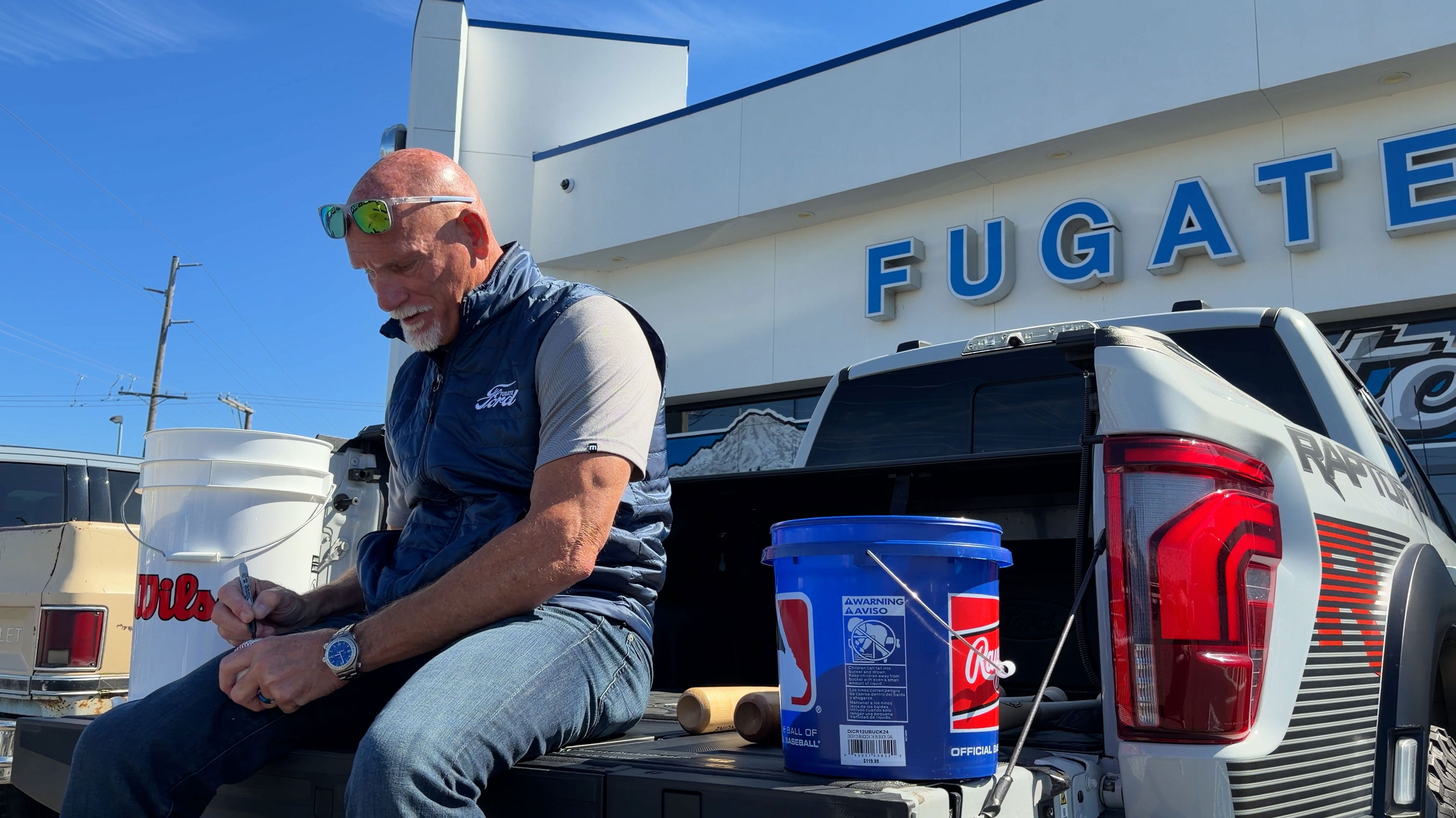Jay Buhner signing baseballs beside a Ford truck at Fugate Ford